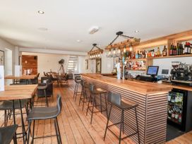A bar area with wooden tables and stools at 6 Stonerush Valley Lanreath