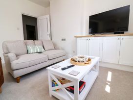 A living room with a sofa and a television at The Old Bank Flat in North Tawton