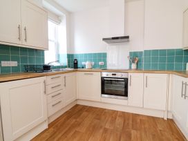 A kitchen with cabinets, an oven, and a sink at The Old Bank Flat in North Tawton
