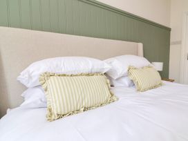 A bedroom with a bed and decorative pillows at The Old Bank Flat North Tawton