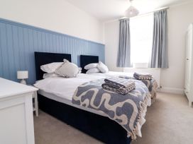 A bedroom with two beds and a wardrobe at The Old Bank Flat in North Tawton