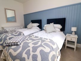 A bedroom with two beds and a nightstand at The Old Bank Flat North Tawton