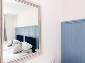 A bedroom with a mirror reflecting a bed at The Old Bank Flat North Tawton