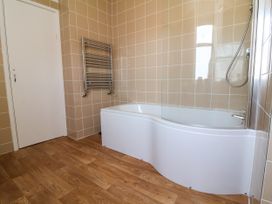 A bathroom with a bathtub and towel radiator at The Old Bank Flat in North Tawton
