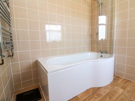 A bathroom with a bathtub and shower at The Old Bank Flat in North Tawton