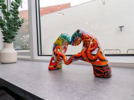 A sculpture and plant on a table near a window at Og's House in Whitby