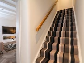 A staircase with a wooden handrail and carpet at Og's House in Whitby