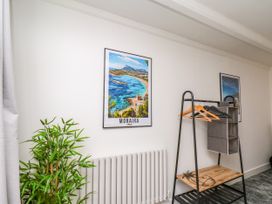 A room with a plant, a poster, a clothes rack, and a radiator at Og's House in Whitby