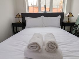A bedroom with a bed and towels at Og's House in Whitby