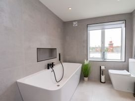 A bathroom with a bathtub and toilet at Og's House in Whitby