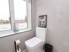 A bathroom with a toilet and window at Og's House in Whitby