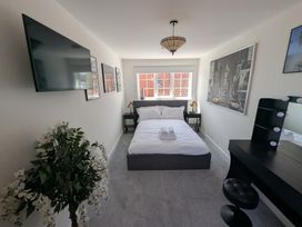 A bedroom with a bed, television, and vanity at Og's House in Whitby
