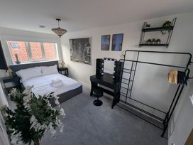 A bedroom with a bed and a mirror at Og's House in Whitby