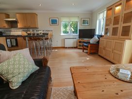 A living room with a sofa and television at Stargazy in Falmouth