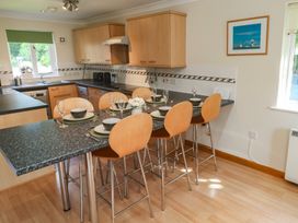 A kitchen with bar stools and tableware at Stargazy in Falmouth