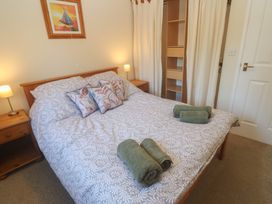A bedroom with a bed and bedside lamps at Stargazy in Falmouth
