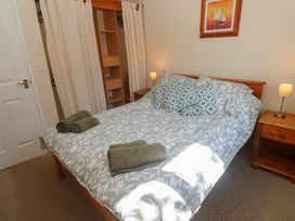 A bedroom with a bed and nightstands at Stargazy in Falmouth