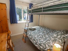 A bedroom with a bunk bed and a desk at Stargazy in Falmouth