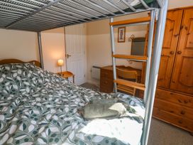 A bedroom with a bed and wooden furniture at Stargazy in Falmouth