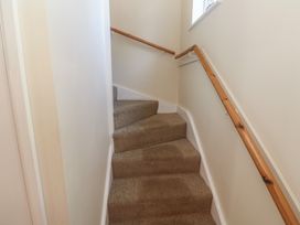 A staircase with carpet and handrail at Stargazy in Falmouth