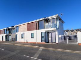 A building with a balcony and gated entrance at 1 Marina View in Pwllheli