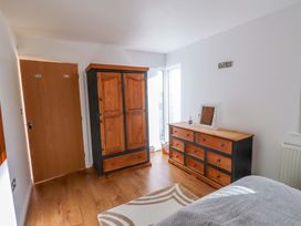 A bedroom with a wardrobe and dresser at 1 Marina View in Pwllheli