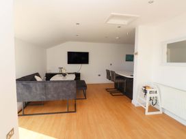 A living room with a sofa and television at 1 Marina View in Pwllheli