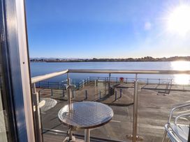 A balcony with a table overlooking water at 1 Marina View Pwllheli