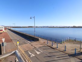 A view of a waterfront area with a road and railing at 1 Marina View Pwllheli