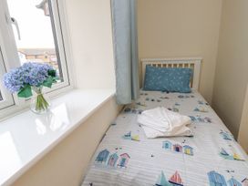 A bedroom with a single bed and a vase of flowers at Harbour View Poole
