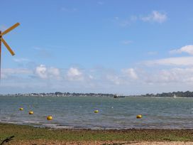 An outdoor view with a windmill and boats on the water at Harbour View Poole