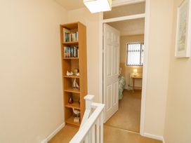 A hallway with a bookshelf and a door to another room at Poole Quay Cottage in Poole