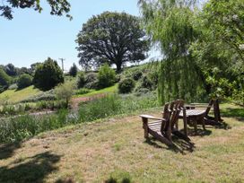 A seating area with chairs near a body of water at Captains Barn in Tiverton