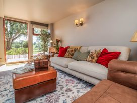 A living room with a sofa and plants at Captains Barn in Tiverton