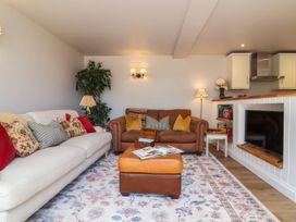 A living room with a sofa and armchair at Captains Barn in Tiverton