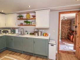 A kitchen with cabinets and sink at Captains Barn in Tiverton