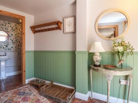 A hallway with a coat rack and sink at Captains Barn in Tiverton