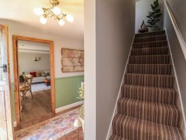 A hallway with a staircase and door at Captains Barn in Tiverton