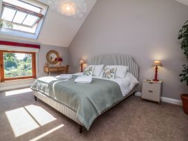 A bedroom with a bed and window at Captains Barn Tiverton