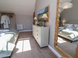 A bedroom with a bed and dressing table at Captains Barn in Tiverton