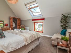 A bedroom with a bed and window at Captains Barn Tiverton