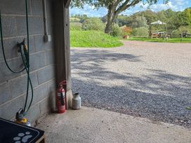 A garage with a hose and fire extinguisher at Captains Barn in Cadeleigh near Tiverton