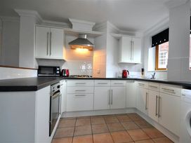 A kitchen with white cabinets and appliances at Old Harbour View in Weymouth