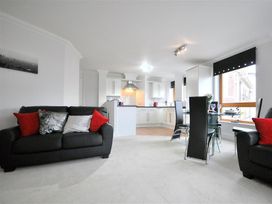 A living room with a sofa and dining area at Old Harbour View in Weymouth