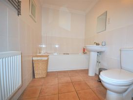 A bathroom with a bath tub, sink and toilet at Old Harbour View in Weymouth