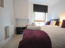 A bedroom with two beds and a window at Old Harbour View in Weymouth