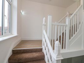 A staircase with a landing and windows at Beachwalk Villa 2 in Whitby
