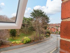 A view of trees and road from a window at Beachwalk Villa 3 in Whitby