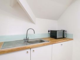 A kitchen with a sink and microwave at Beachwalk Villa 3 in Whitby