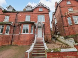An outdoor view of a brick building with a staircase at Beachwalk Villa 3 in Whitby